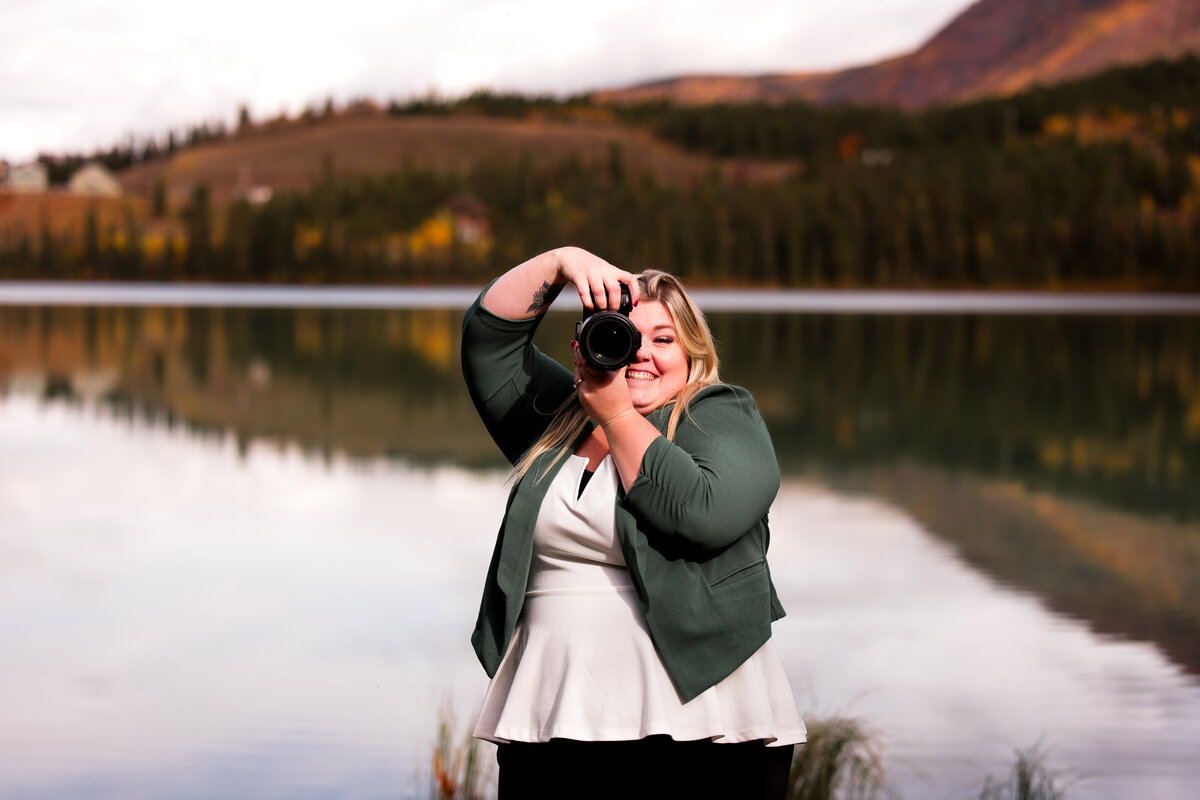 Edmonton wedding photographer holding her camera and smiling 