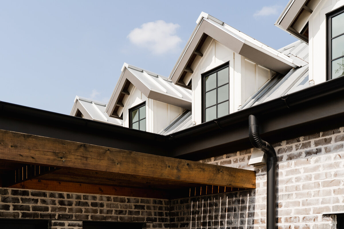dormer windows next to wooden overhang on brick building
