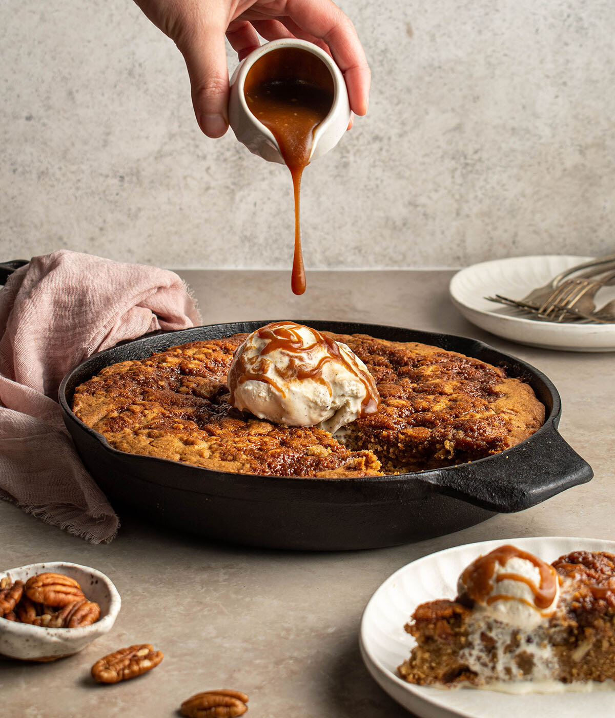 action pouring shot of caramel on a skillet cookie