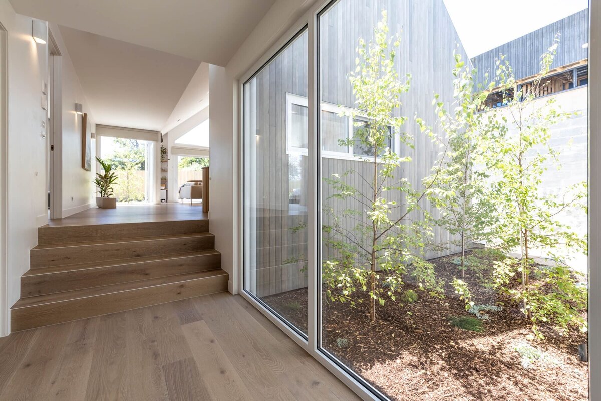 Hallway with large window showing green trees