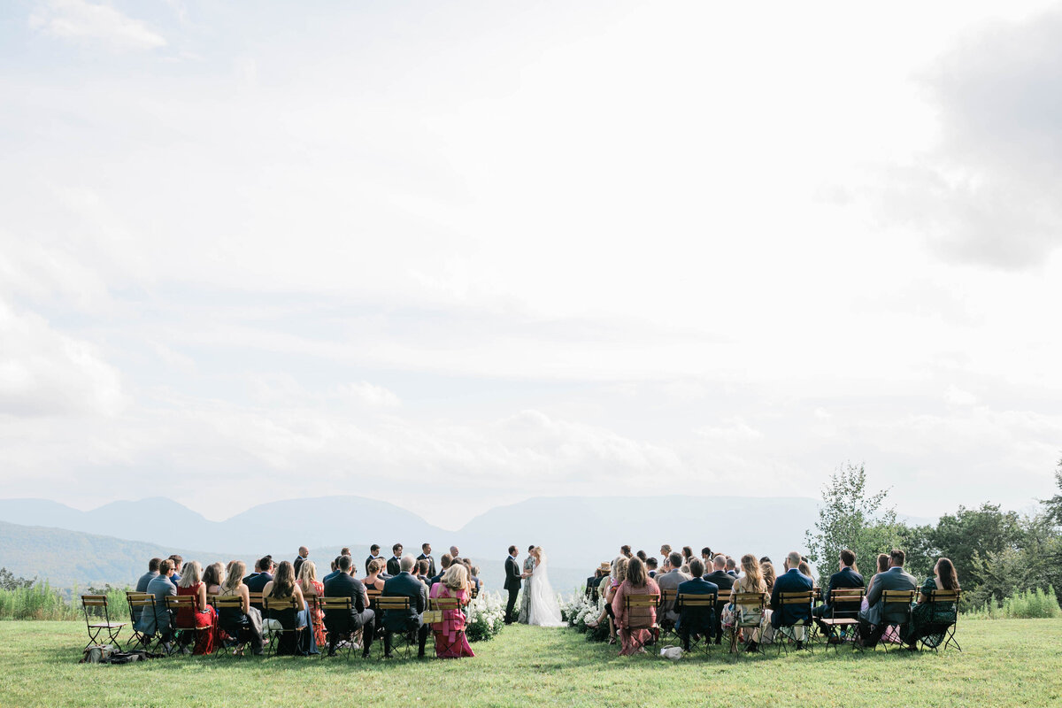 Wedding attendees stand as bride and groom meet at the altar
