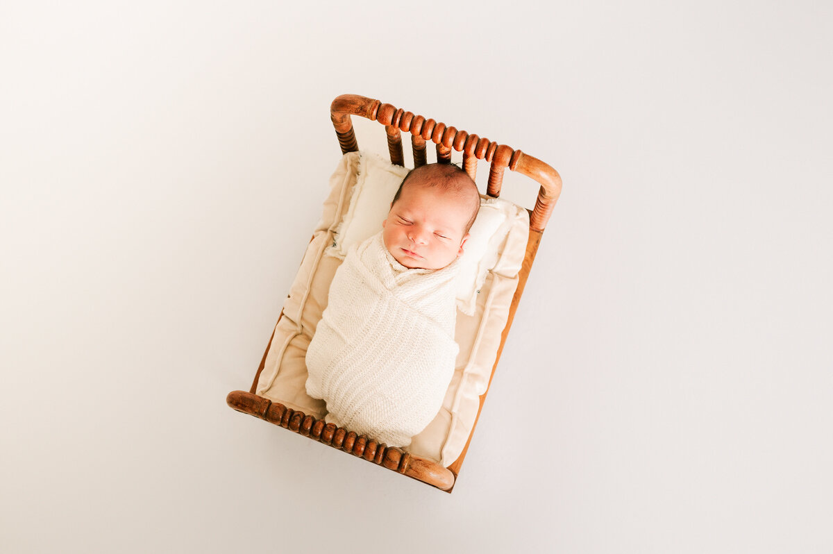 newborn pictures in Springfield MO of baby boy in wood crib