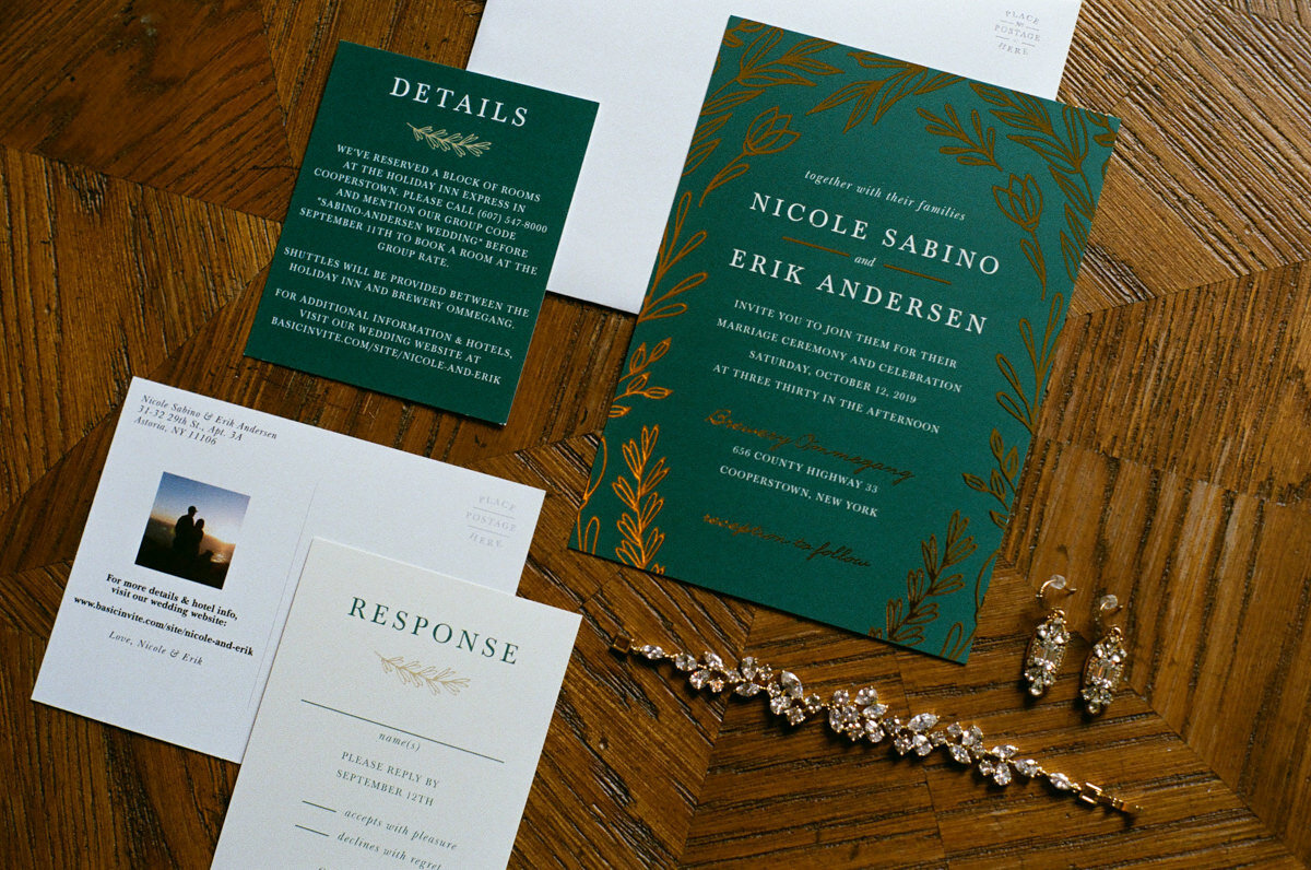 Wedding invitations and jewelry laying next to each other.