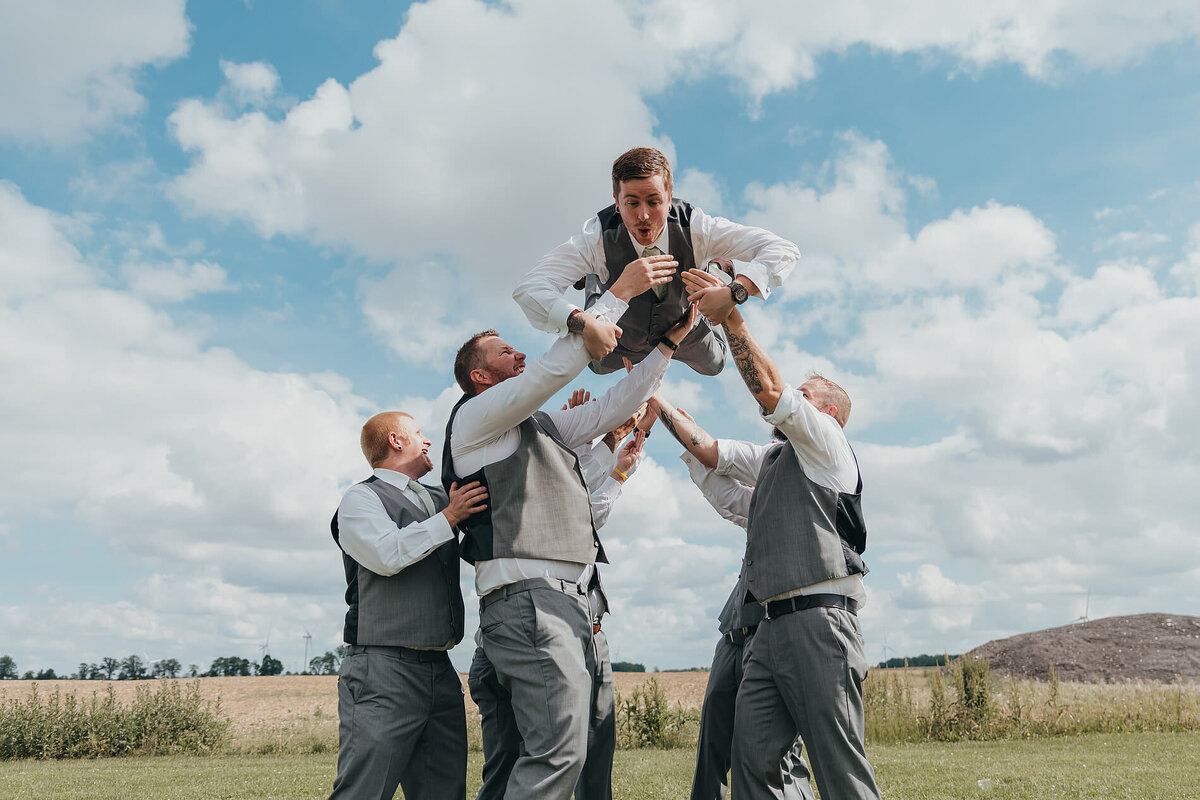 groomsmen-lifting-groom