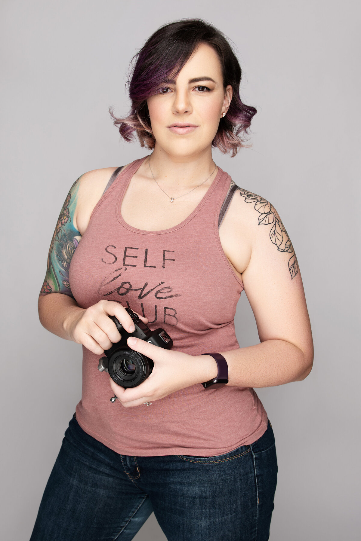 olivia fierce headshot with cannon camera pink tank top in jeans