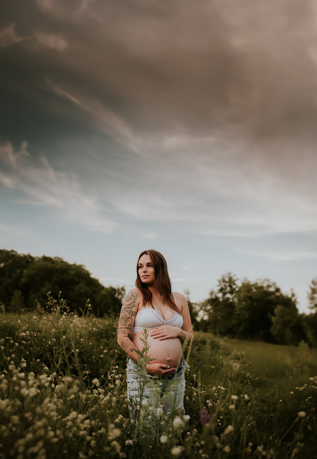 An enchanting sunset maternity shoot on Stillwater Hill, MN, highlighting the glowing beauty of an expectant mother bathed in golden light.