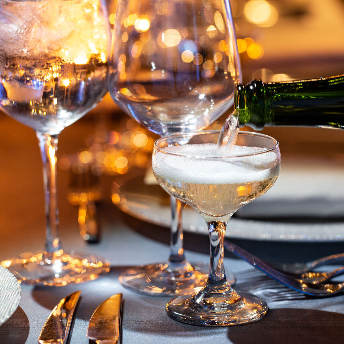 A bottle of wine is being poured into a wine glass