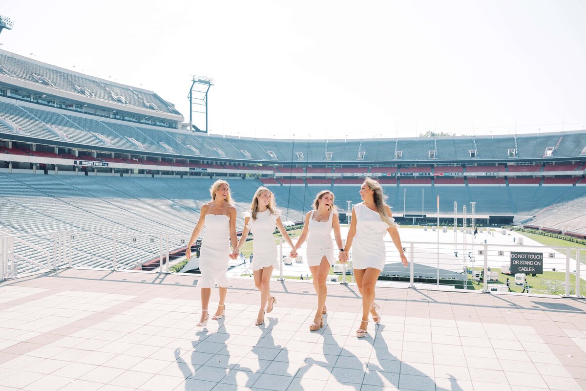 Four girls in white dresses at the UGA Stadium