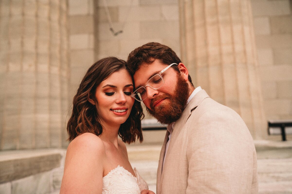 A bride & groom embrace with soft smiles in an intimate wedding portrait, highlighting moody & editorial wedding photography in Pittsburgh.