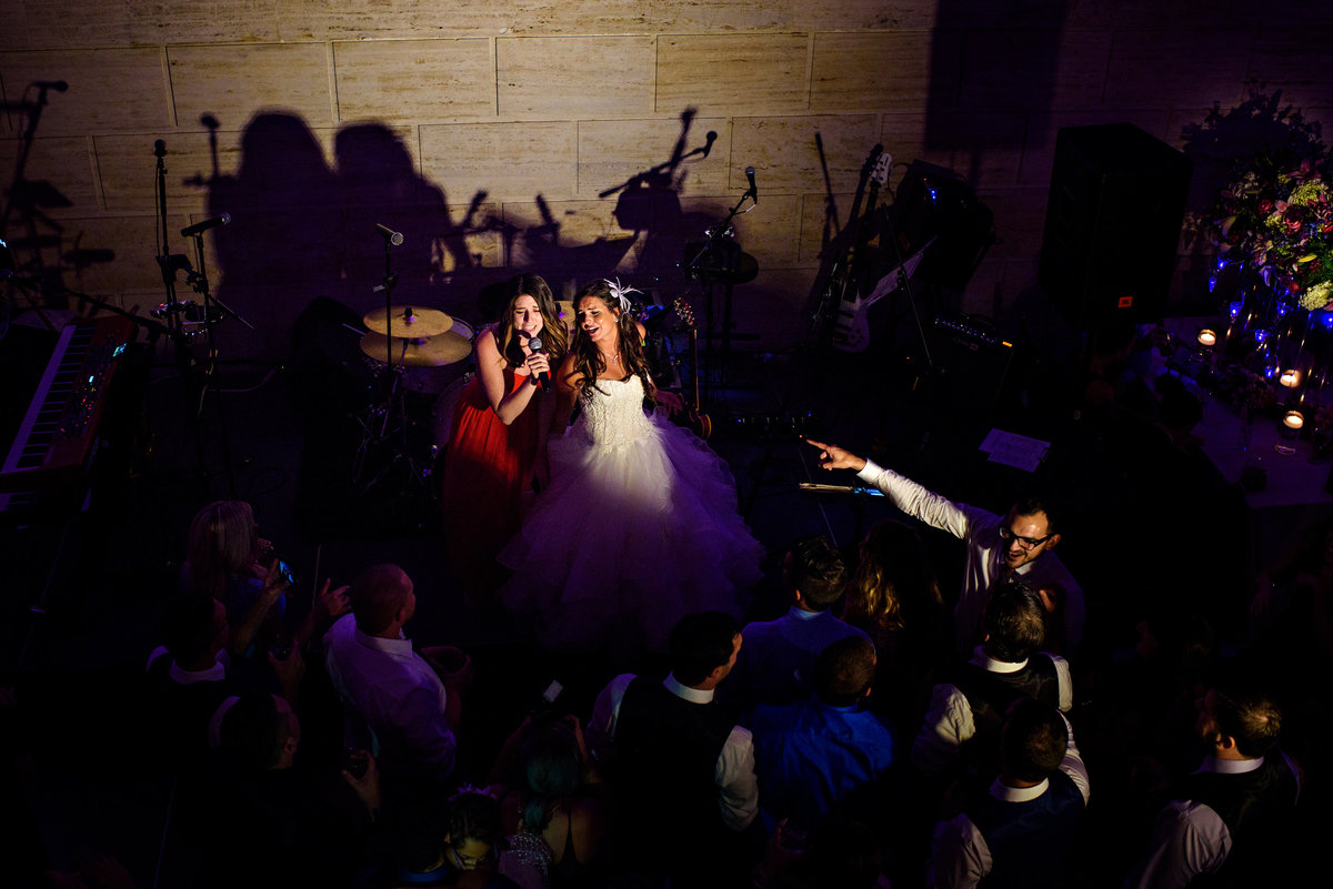 A bride and her maid of honor hop on stage and sing with the band.
