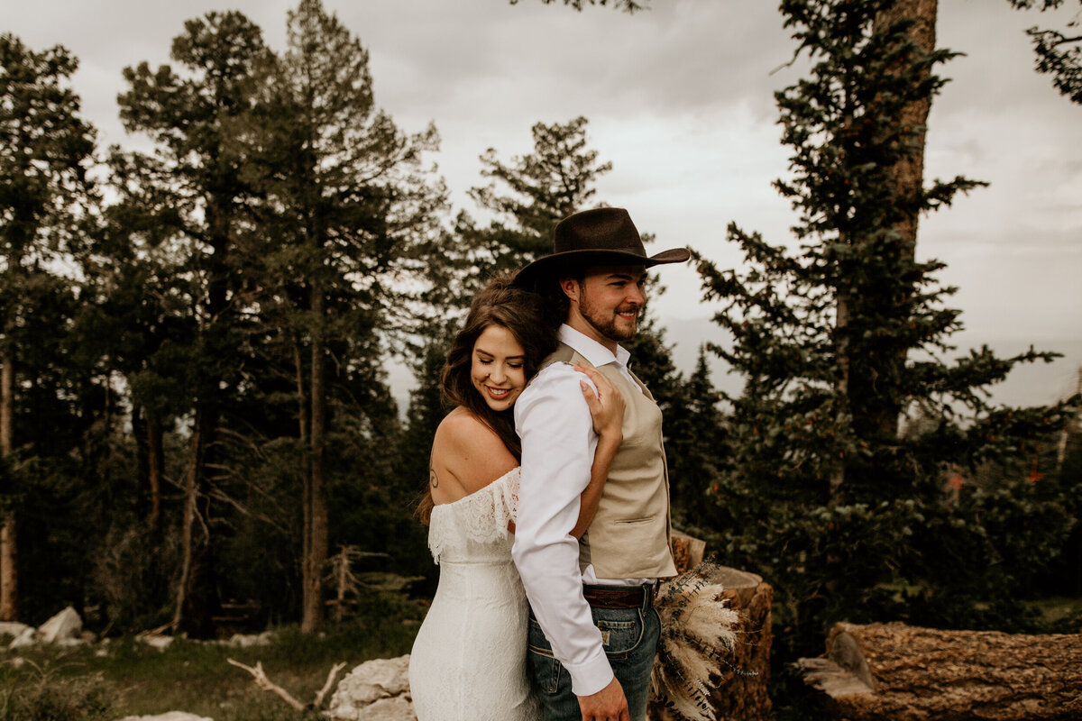 bride hugging her new husband from behind in New Mexico