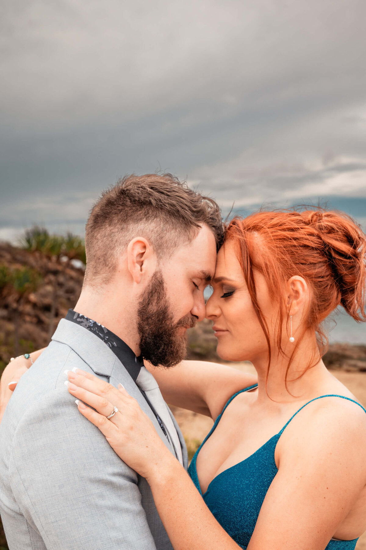 Engaged couple on the beach, joyfully posing for their engagement photos taken by a Townsville wedding photographer. - photo by Jamie Simmons