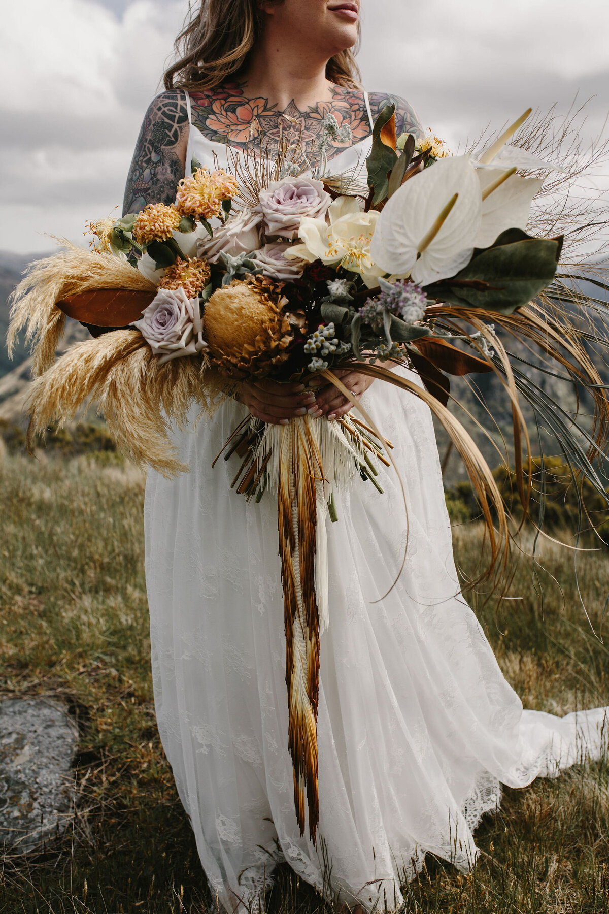 The Vase Floral Co - bride holds large flower bouquet in natural tones