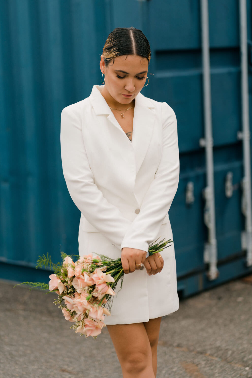 woman looking down at her feet while holding a bouquet