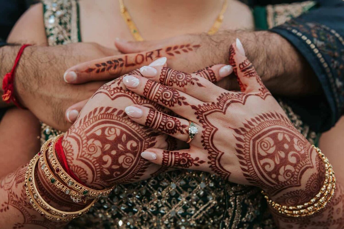 The bride holding the groom's hands on her chest with her mehndi visible in Philadelphia.