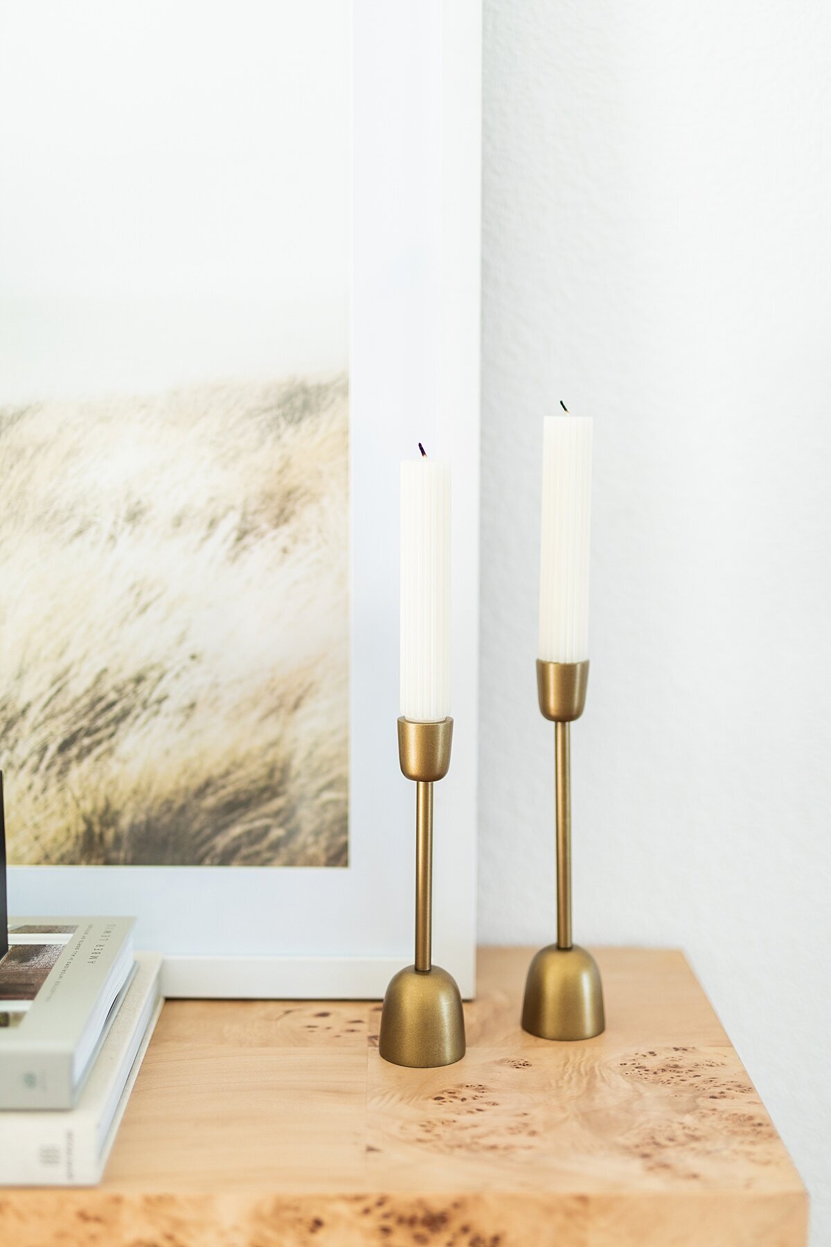 White tapered candles in brass candle holders.