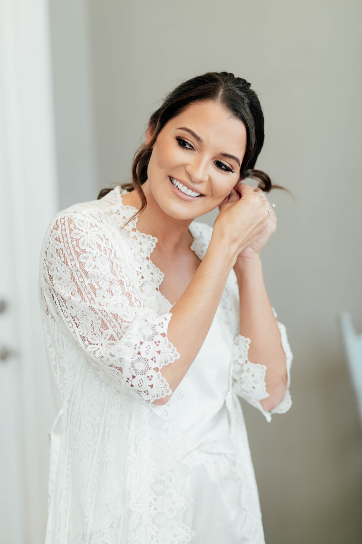 Close up of bride putting in her earrings. 