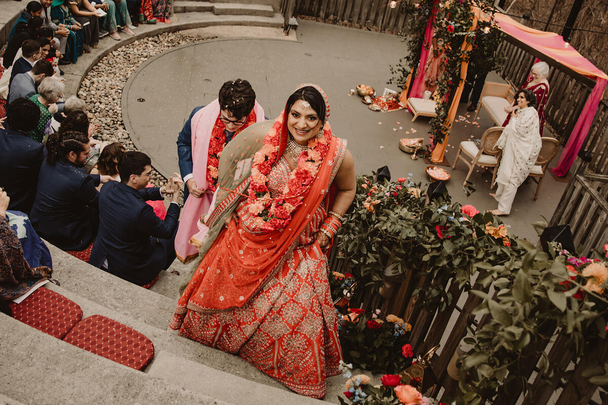 A newlywed walking up a concrete amphitheater 