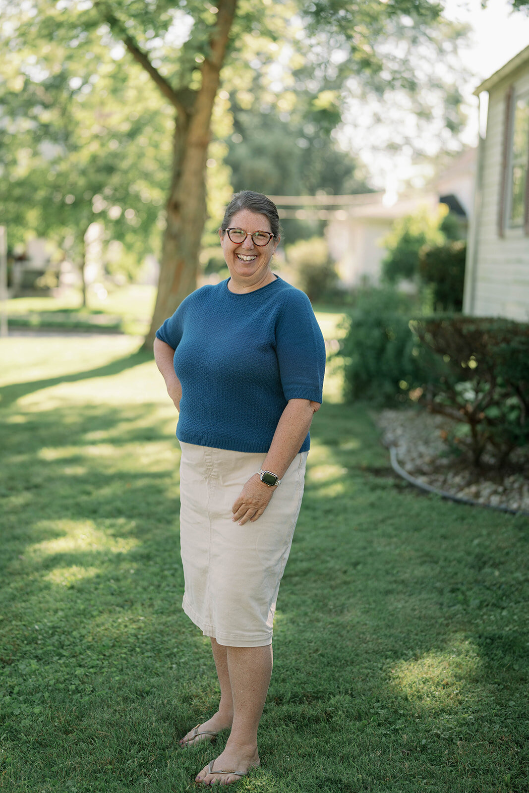 Full-body outdoor portrait of a team member standing in a yard during a branding photo session in Indiana.