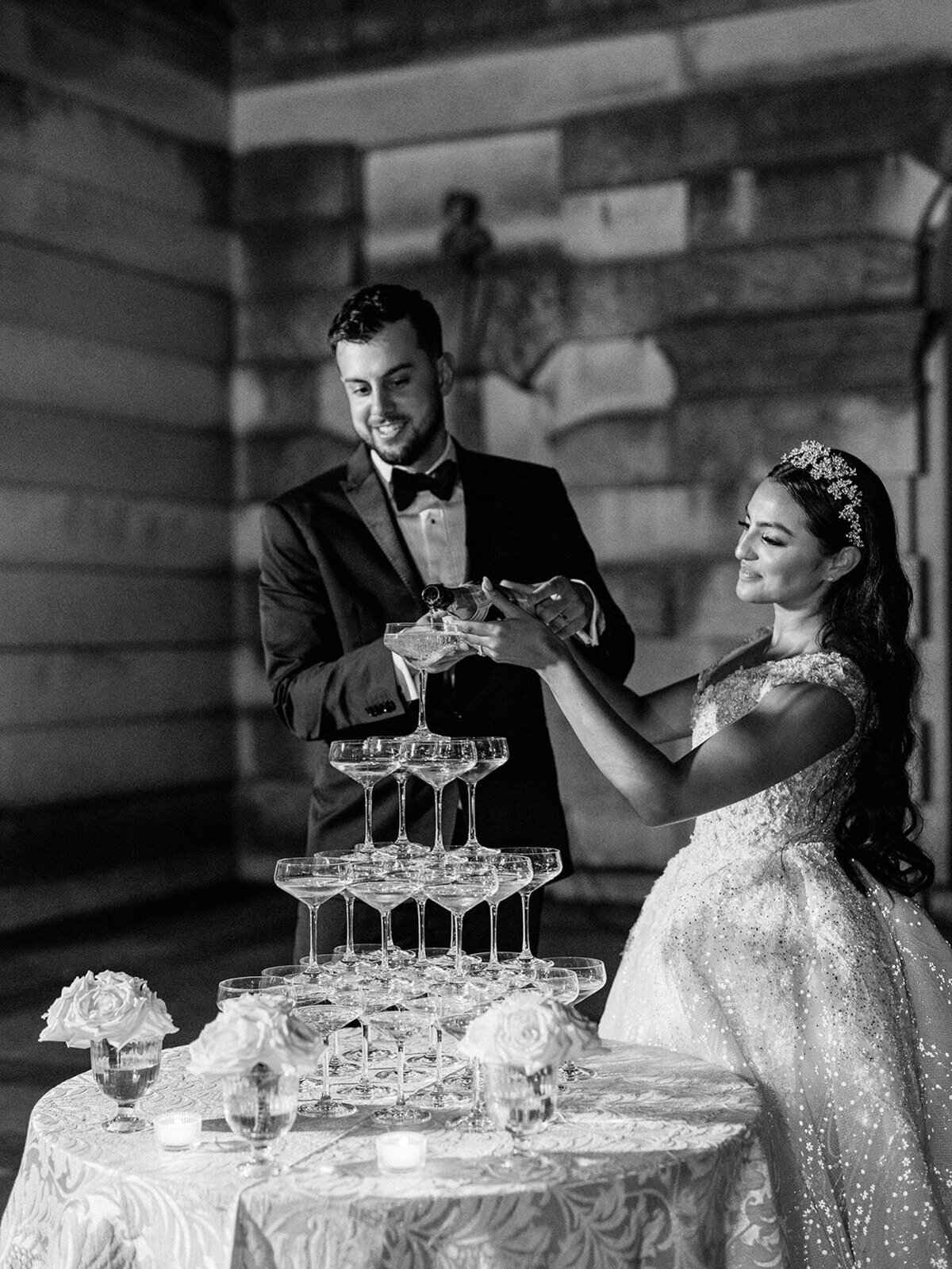 Bride and groom pour champagne for their champagne tower