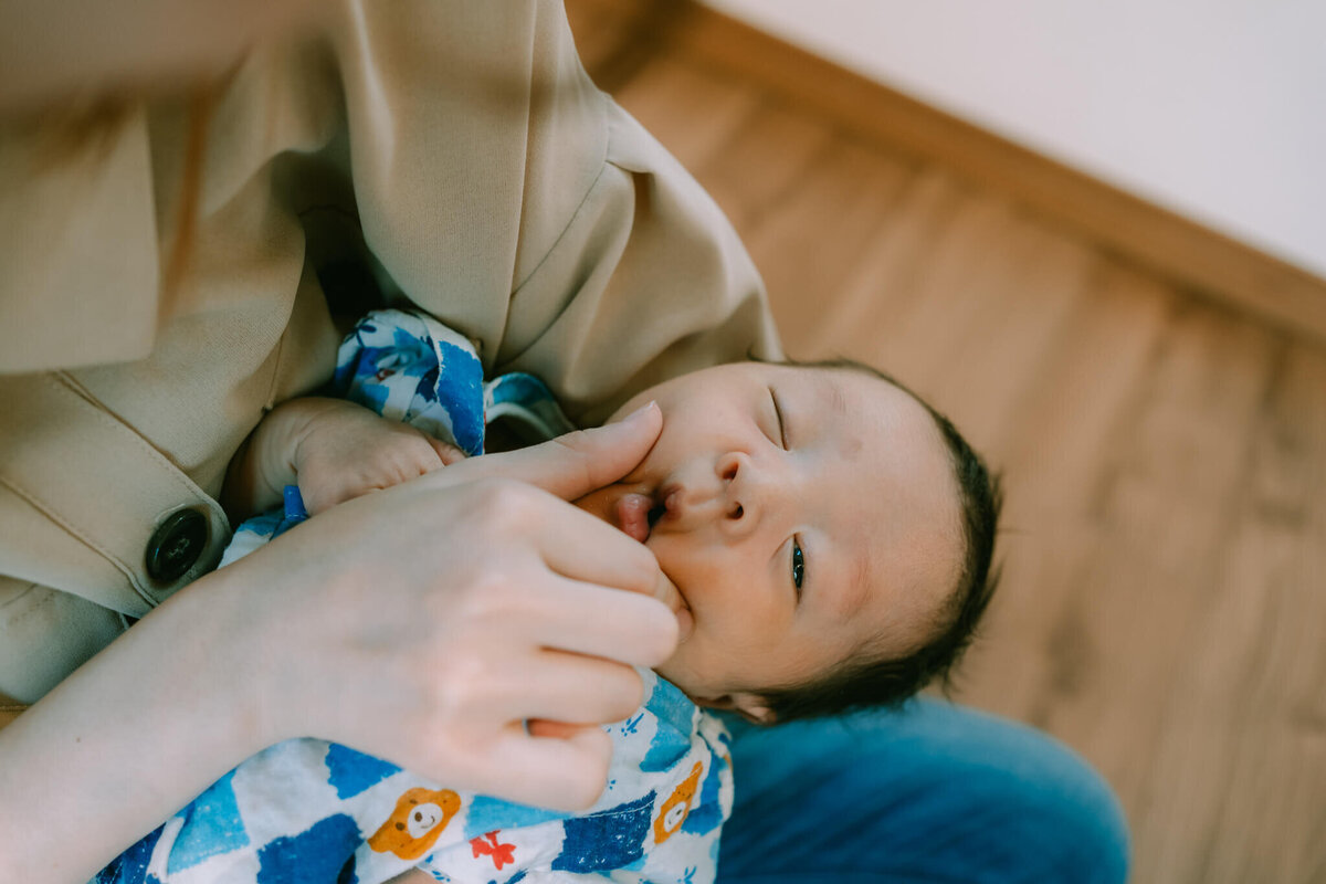 頬をむにっとされている赤ちゃん