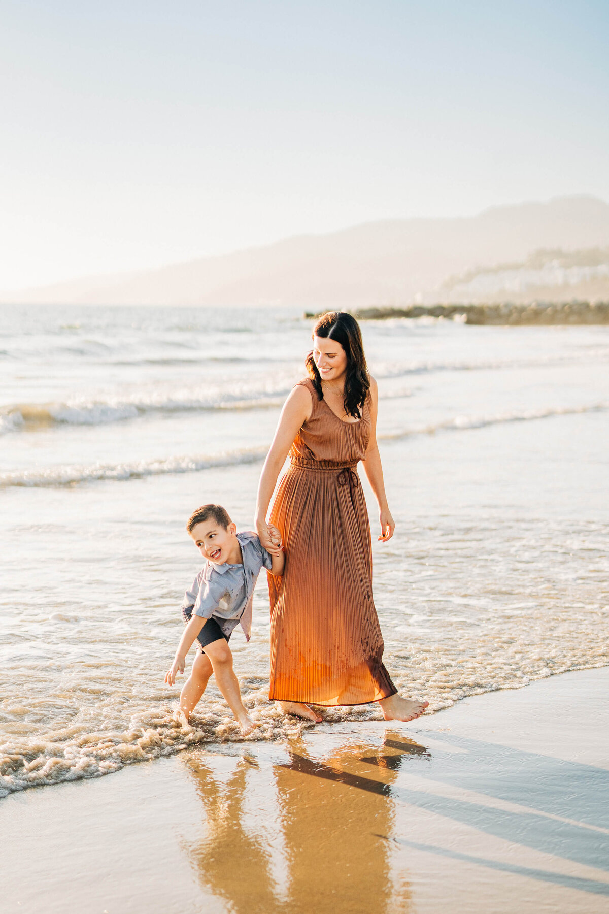 Mom and toddler walking on the beach in Pacific Palisades. Fall mini-session.
