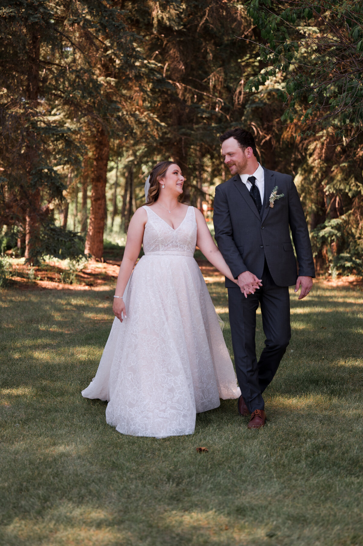bride and groom holding hands and walking, looking at each other with love during candid, documentary style wedding portraits