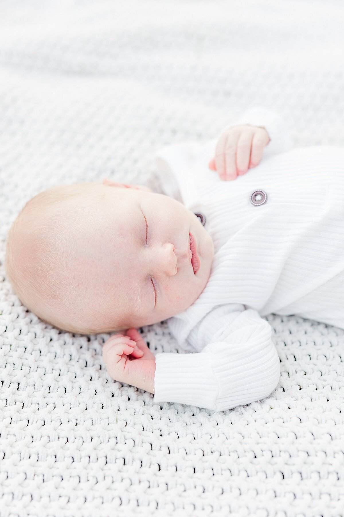 baby lays on blanket during outdoor newborn photo session at Heard Farm in Wayland Massachusetts with Sara Sniderman Photography