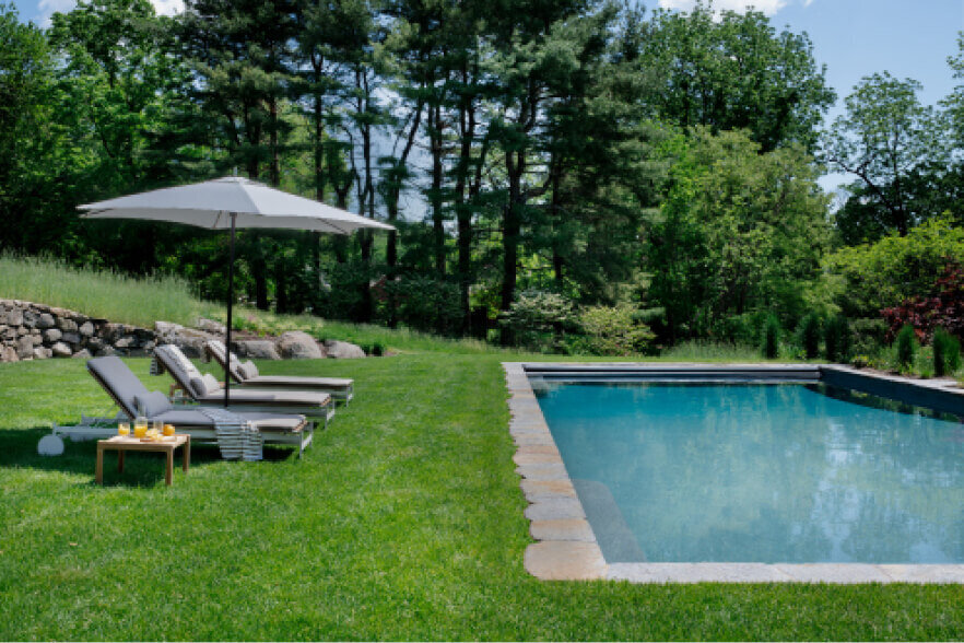 Interior decorator in Boston selects modern furniture for a new pool area, enhancing the space with sleek, stylish pieces perfect for outdoor relaxation.