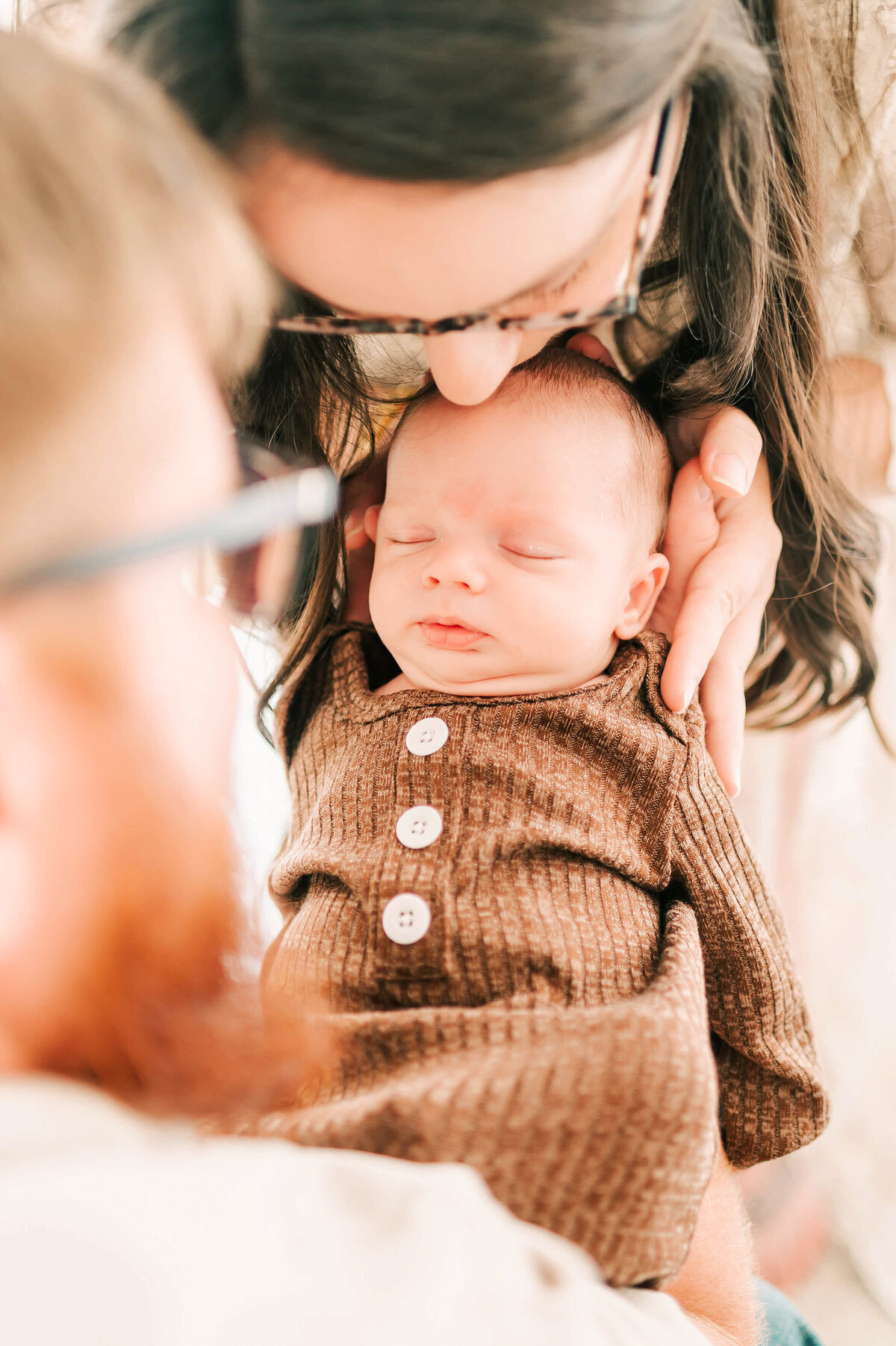 parents cuddling newborn baby boy during newborn photography in Branson