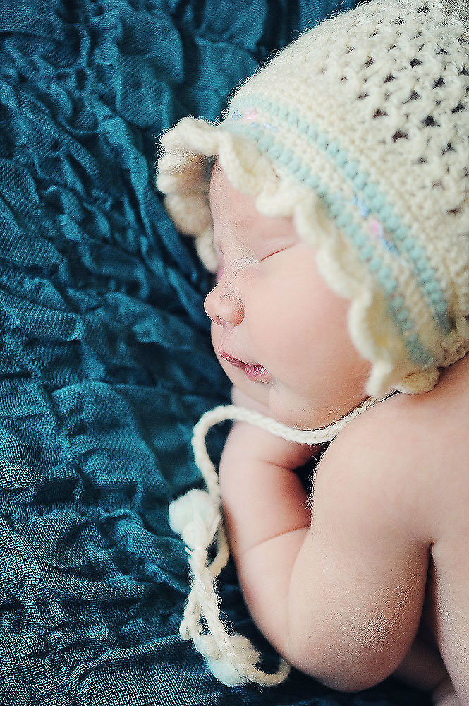 newborn baby wearing her grandmothers knit bonnet