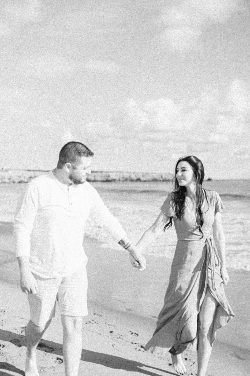 couple-holds-hands-at-beach