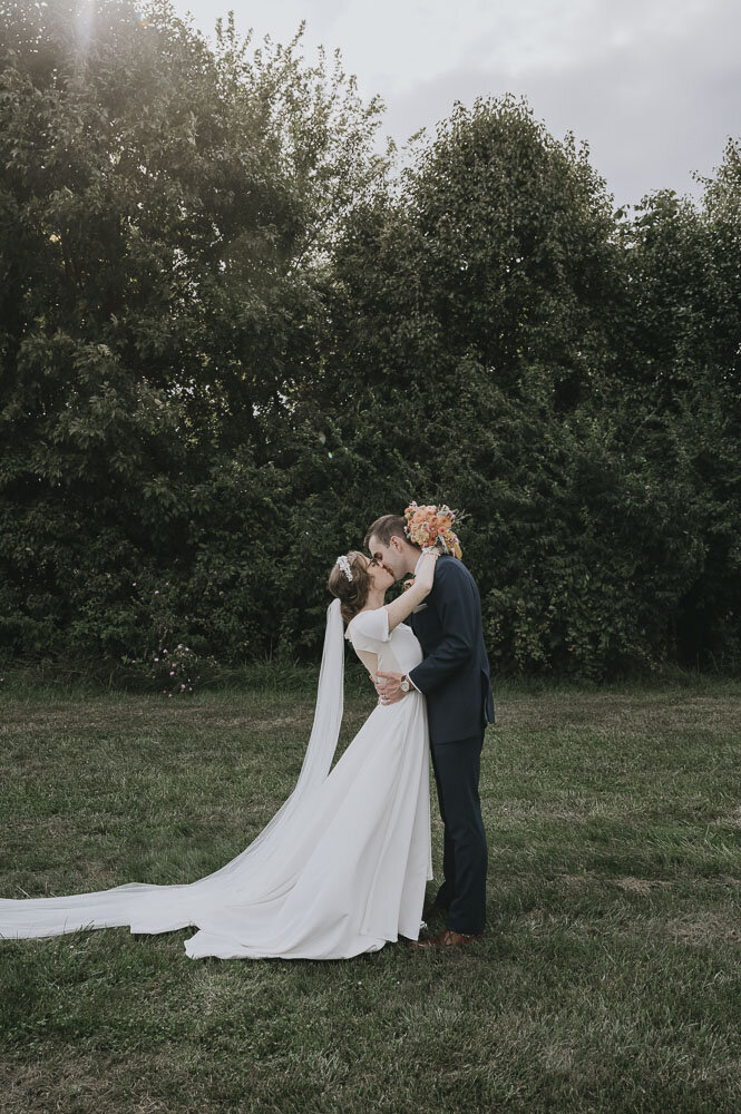 outdoor portrait bride and groom kissing