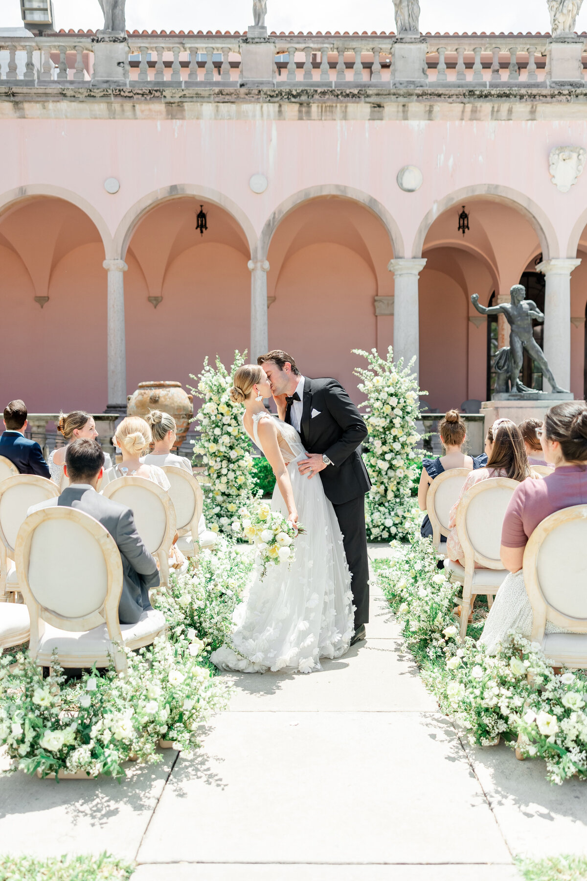 couple kissing down the wedding aisle taken by wedding photographer in florida