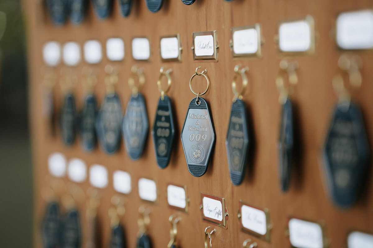 Wedding welcome sign that looks like hotel tags hanging from a wooden board