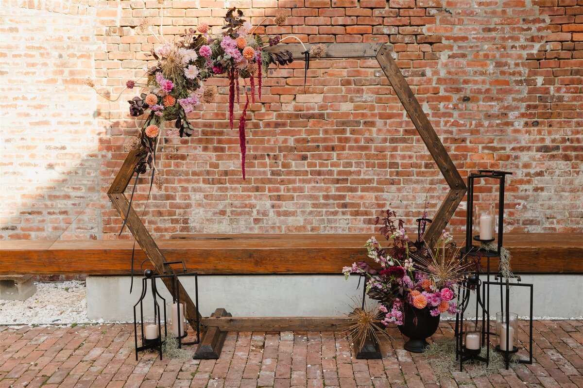 Hexagon wooden ceremony backdrop with cascading flowers