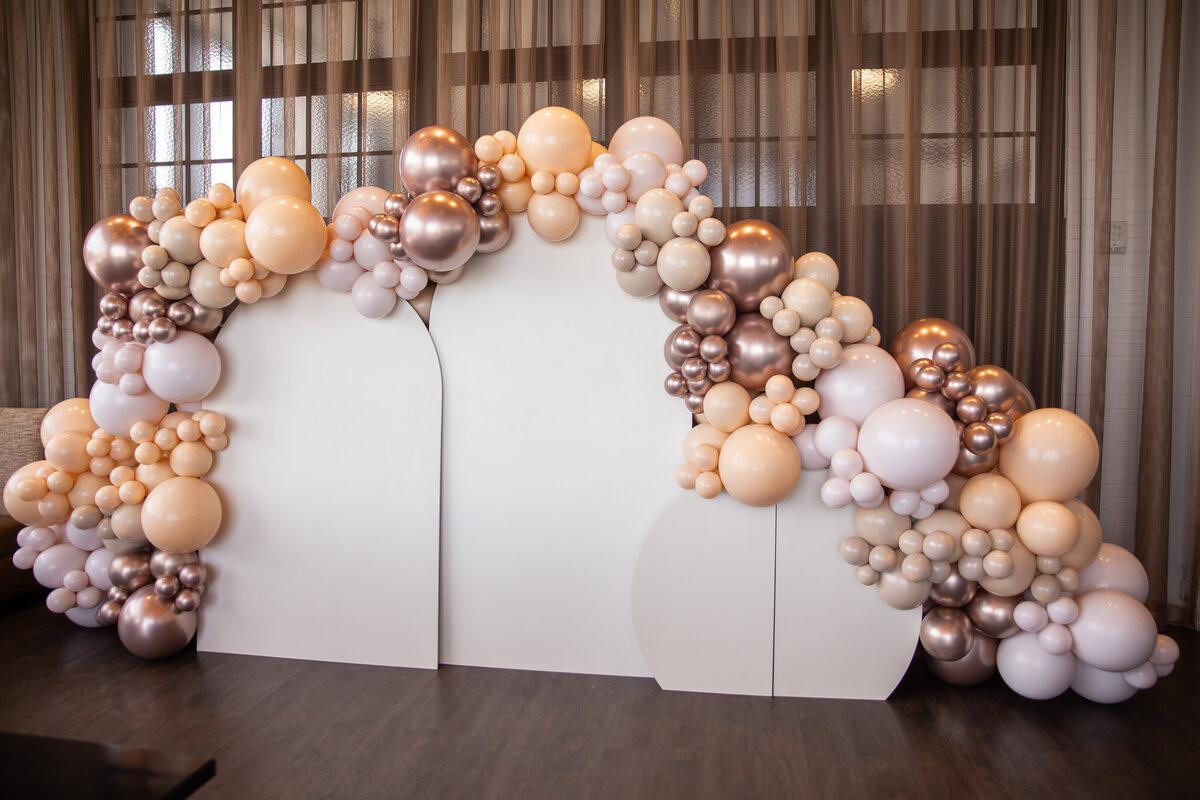 Metallic and white balloons attached to giant white wooden backdrops