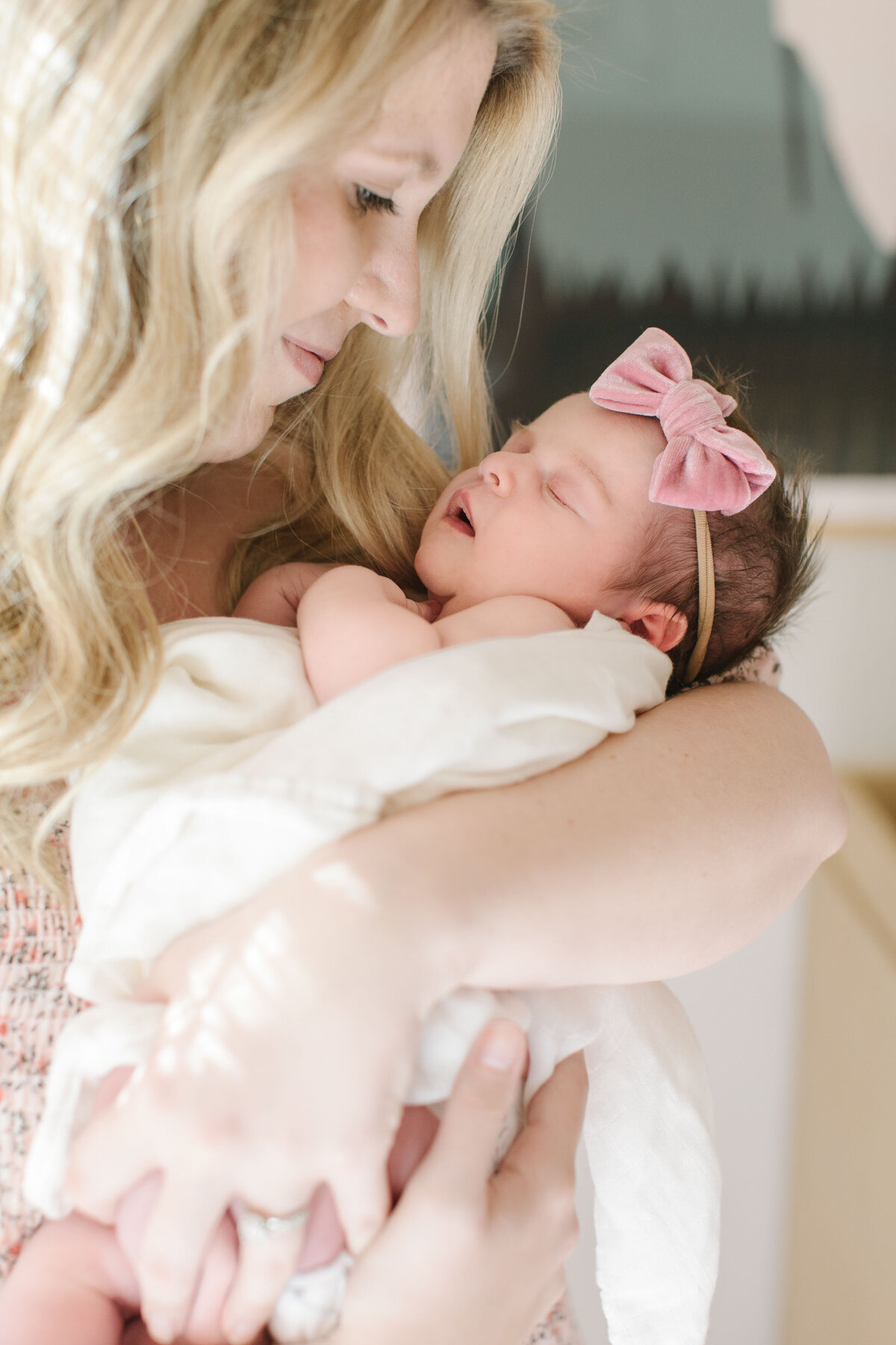 mother holding newborn girl in arms and gazing down at her