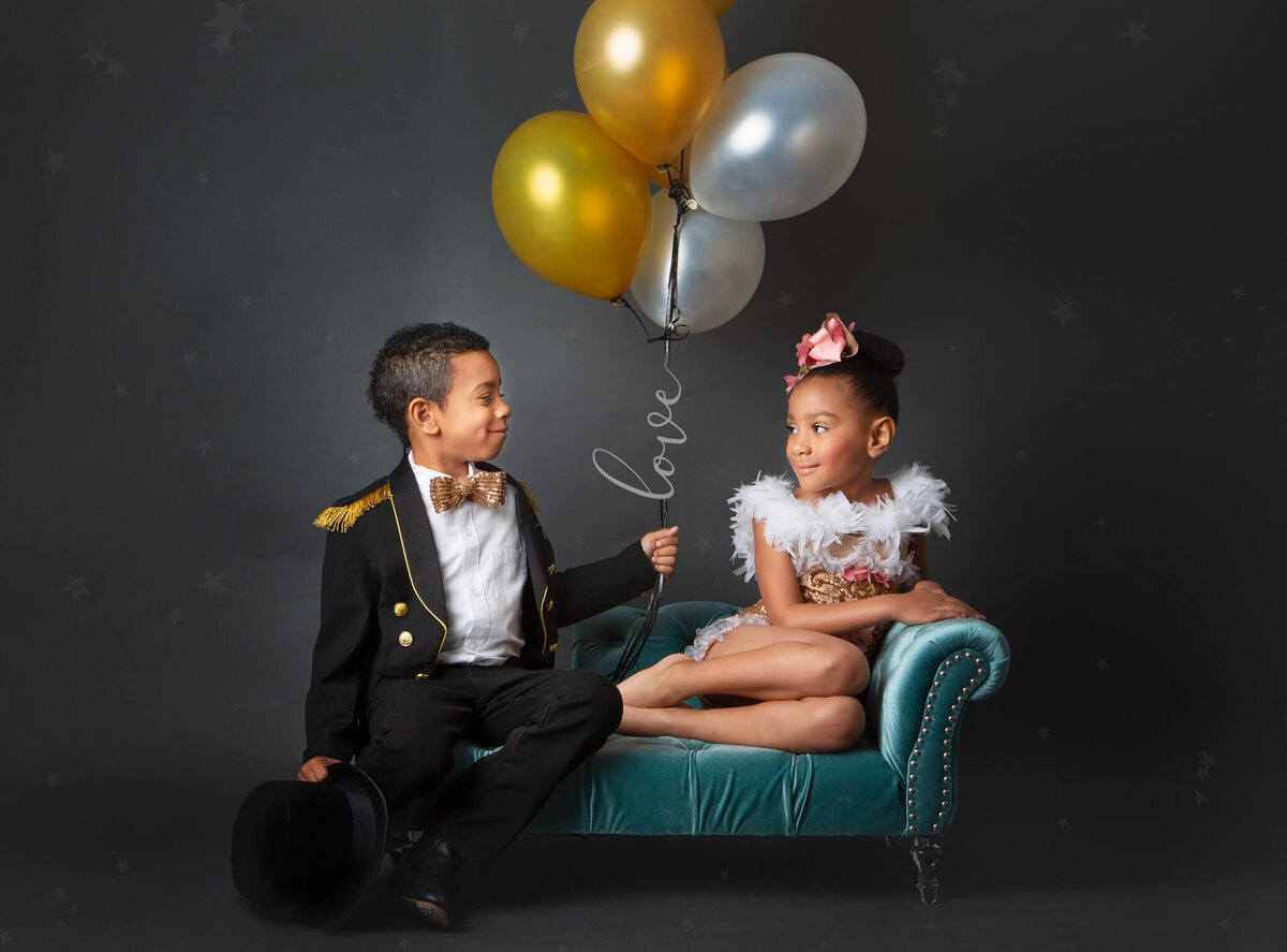 Brother and sister holding balloons and looking at each other in a studio photoshoot in Woodland Hills - Los Angeles Children’s Photographer