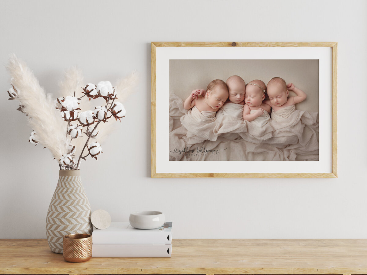 framed canvas of four babies snuggled together