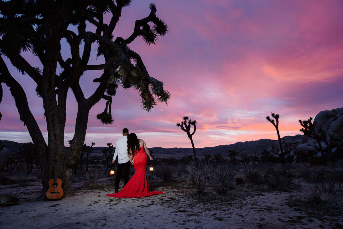 Joshua Tree Elopement with bride and groom watching vibrant sunset with lanterns