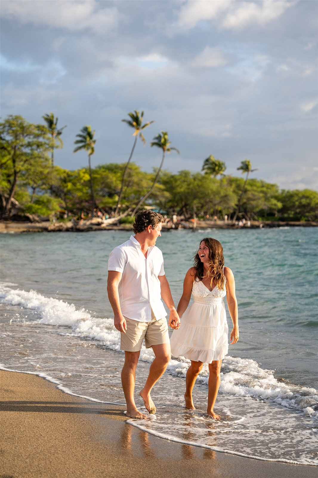 Hawaii engagement photos of couple walking across beach