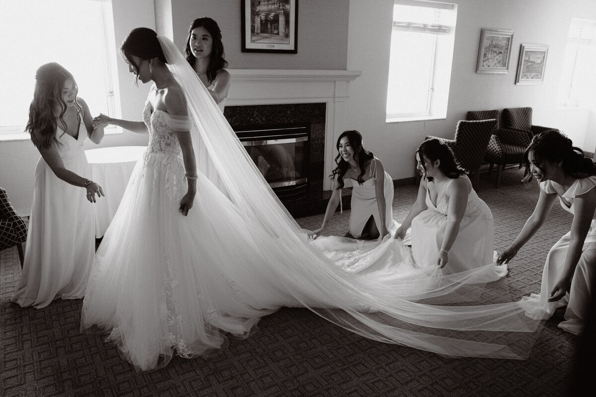 bridesmaids help the future wife get ready by laying out her dress