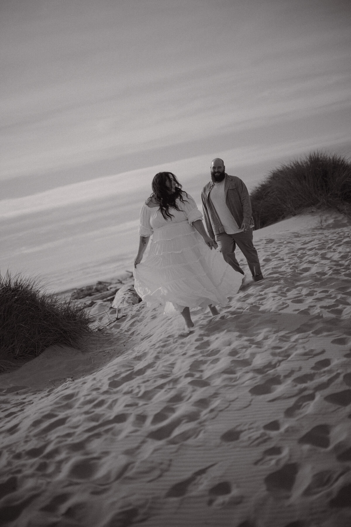 Couple running on the beach at the Oregon coast 