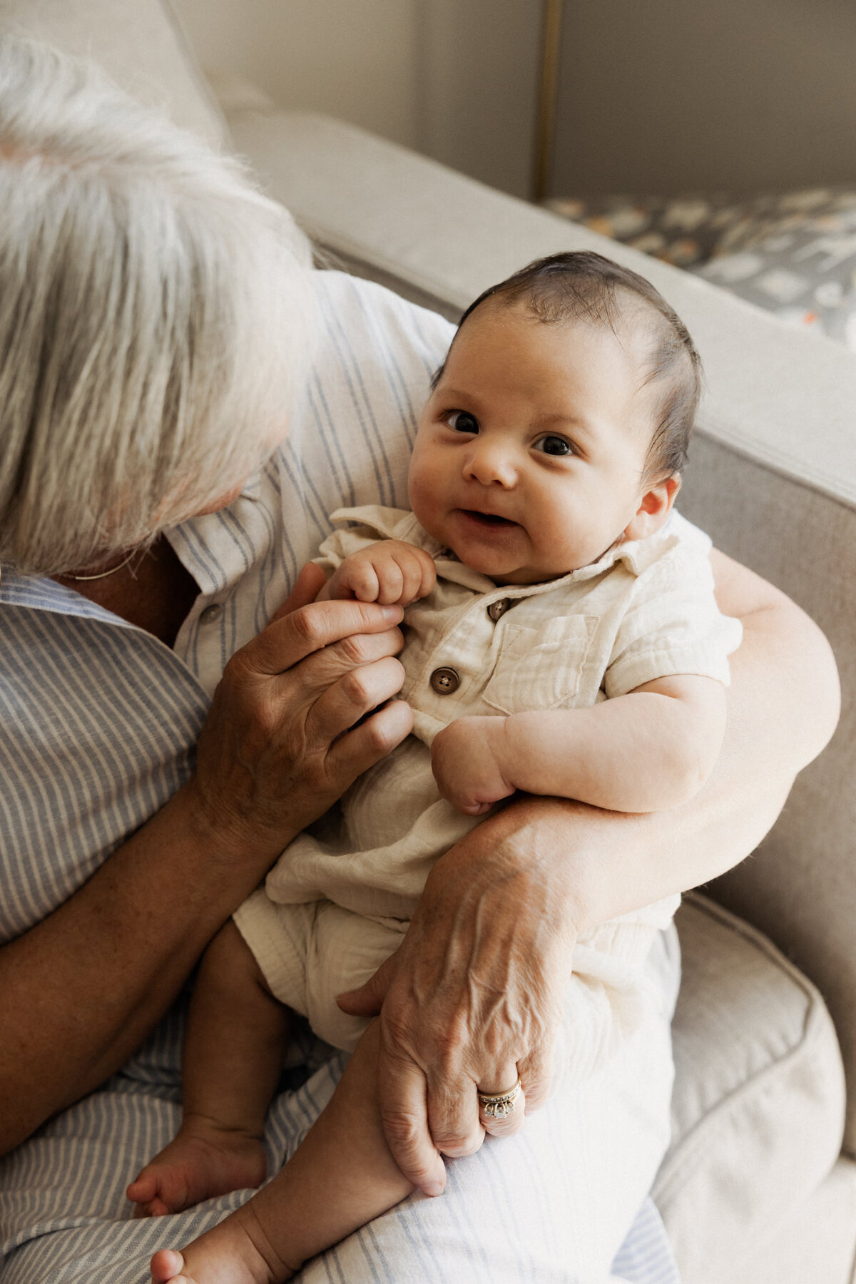 A person holding a newborn as they smile 