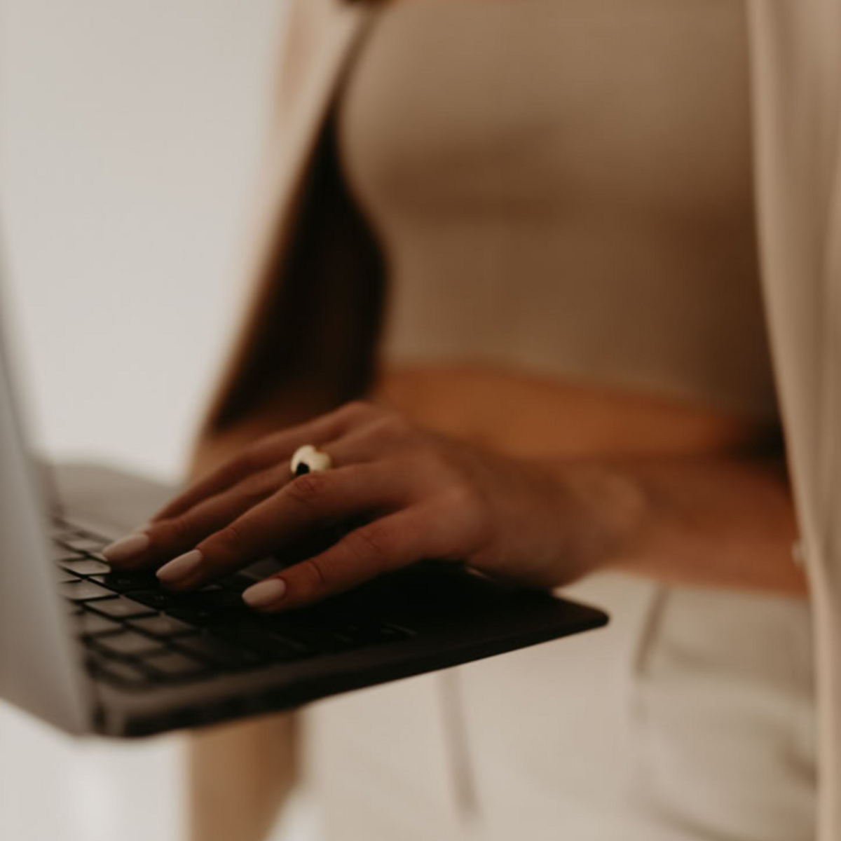 Elegant hands typing on a laptop—representing private coaching sessions with The Clair Agency to rebuild confidence and create clarity in love.