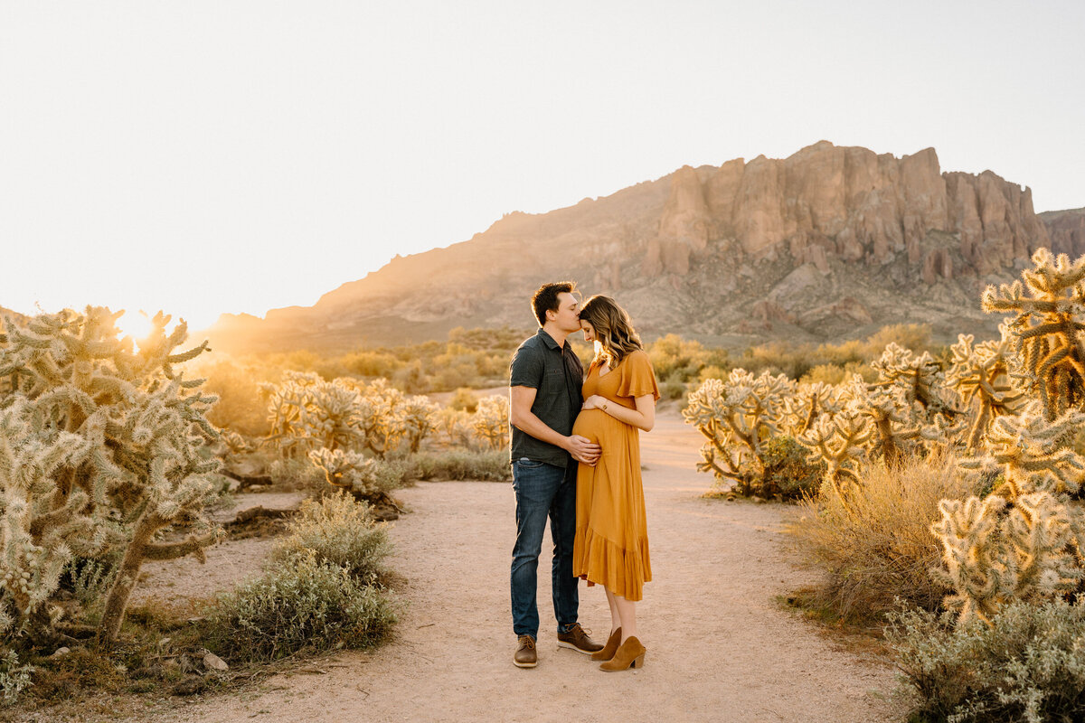 expecting couple poses in arizona landscape
