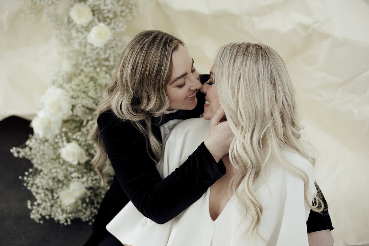 brides-kissing-with-white-flowers
