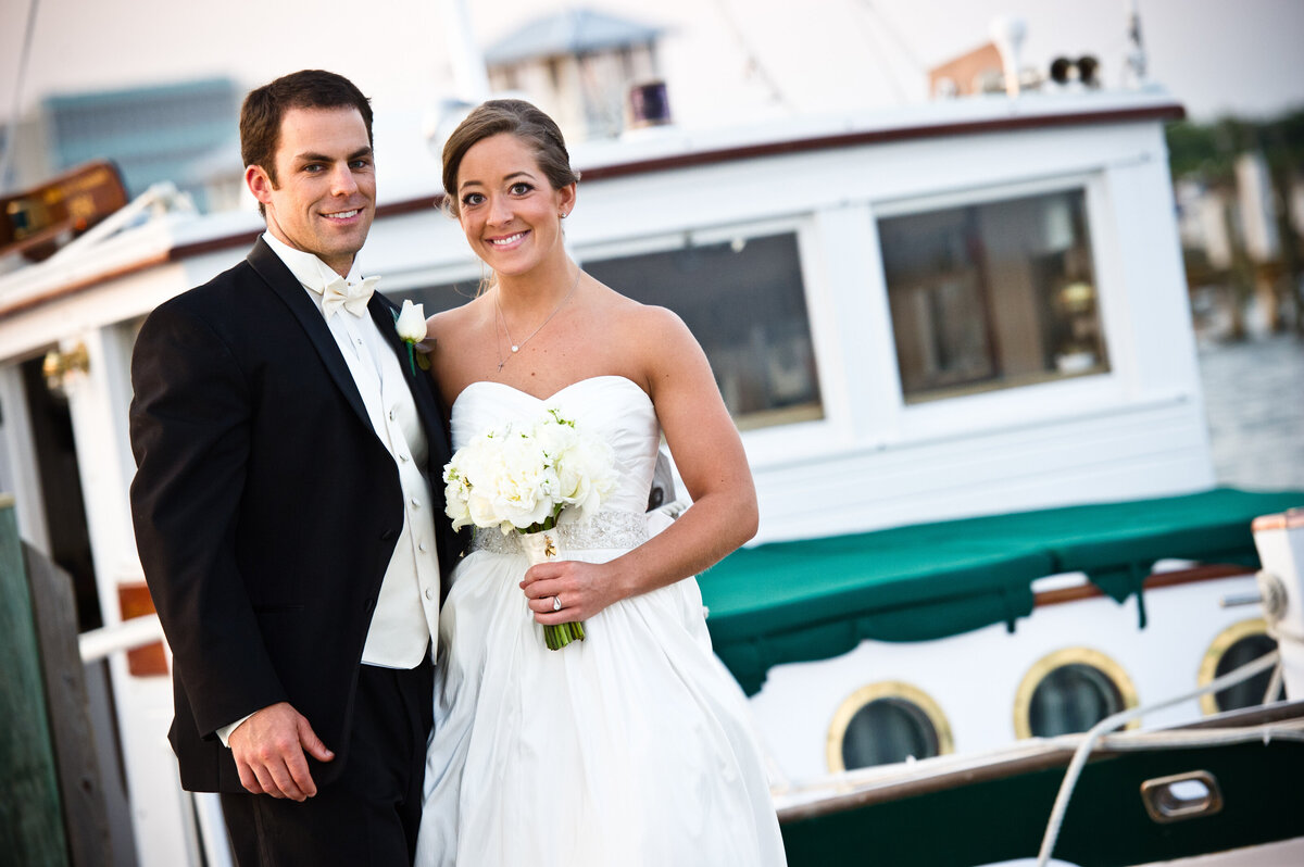 Bride and groom with wood yacht in the background in Gulfport