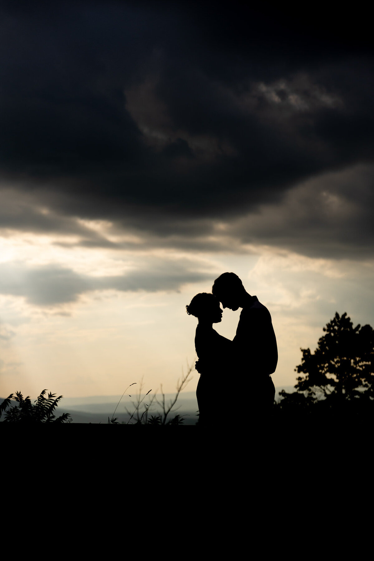 Couple at sunset romantically holding each other with touching foreheads 